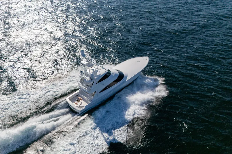 Galati Yacht Sales Trade Yacht Photos Pics 2021 Viking 72 Enclosed Bridge yacht cruising on open water, aerial view.