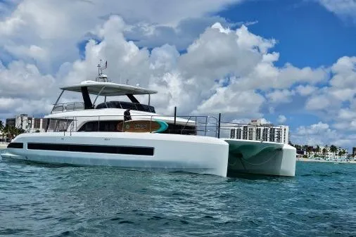 Sunlove Yacht Photos Pics 2024 Lagoon SIXTY 7 yacht on water with cityscape background and cloudy sky.