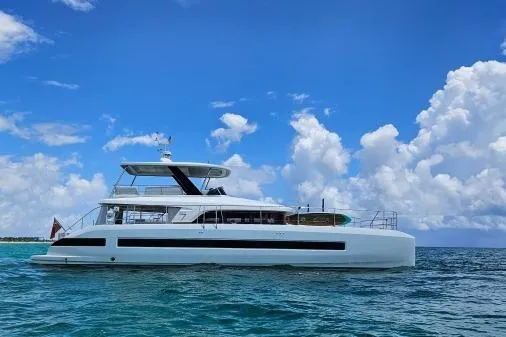 Sunlove Yacht Photos Pics 2024 Lagoon SIXTY 7 yacht cruising on a clear blue ocean under a vibrant sky.