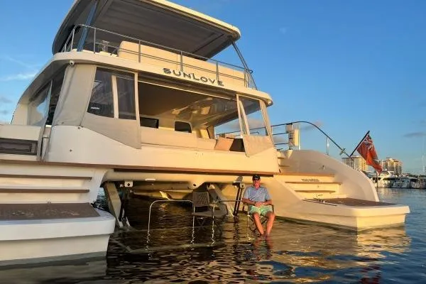 Sunlove Yacht Photos Pics 2024 Lagoon SIXTY 7 yacht "SUNLOVE" at sunset with person relaxing on deck.