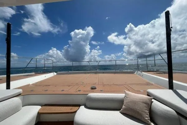 Sunlove Yacht Photos Pics 2024 Lagoon SIXTY 7 yacht deck with ocean view and cloudy sky.