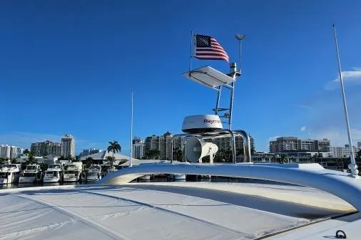 Sunlove Yacht Photos Pics 2024 Lagoon SIXTY 7 yacht with American flag, docked in marina under clear blue sky.