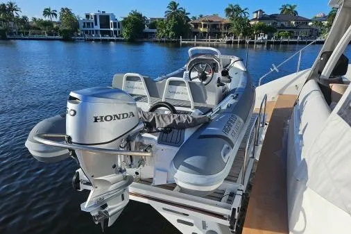 Sunlove Yacht Photos Pics 2024 Lagoon SIXTY 7 yacht with a Honda-powered tender on a scenic waterfront.