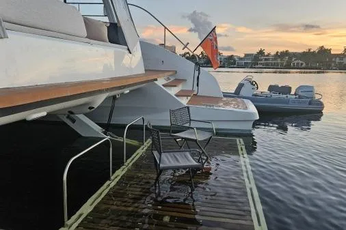 Sunlove Yacht Photos Pics 2024 Lagoon SIXTY 7 yacht with a submerged deck and chair at sunset.