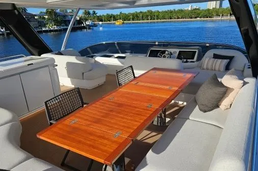 Sunlove Yacht Photos Pics 2024 Lagoon SIXTY 7 yacht interior with elegant seating and wooden table, overlooking serene waterfront.