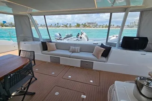 Sunlove Yacht Photos Pics 2024 Lagoon SIXTY 7 yacht interior with ocean view, featuring seating and dining area.