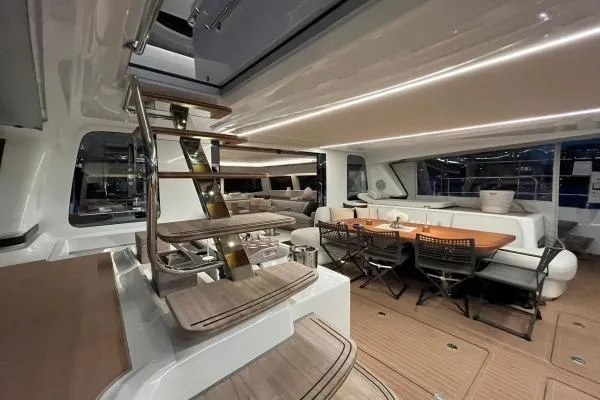 Sunlove Yacht Photos Pics Luxurious interior of 2024 Lagoon SIXTY 7 yacht with elegant dining area and modern staircase.