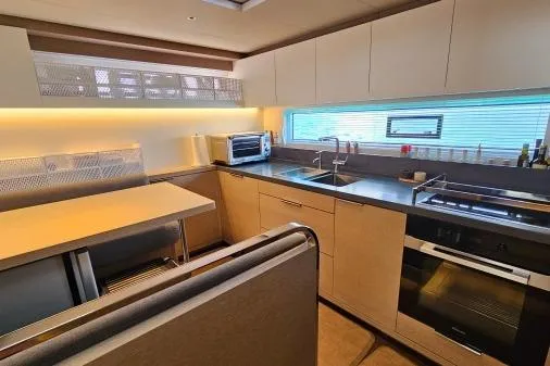 Sunlove Yacht Photos Pics Modern kitchen interior of 2024 Lagoon SIXTY 7 yacht with sleek cabinetry and appliances.