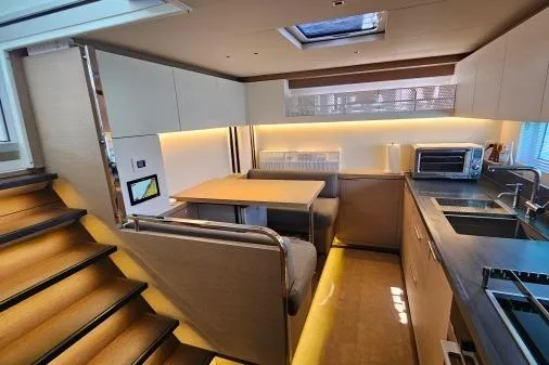 Sunlove Yacht Photos Pics Luxurious 2024 Lagoon SIXTY 7 yacht interior with modern kitchen and dining area.