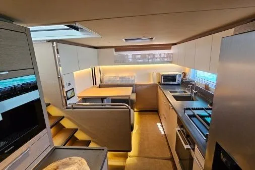 Sunlove Yacht Photos Pics Luxurious interior of 2024 Lagoon SIXTY 7 yacht featuring modern kitchen and dining area.