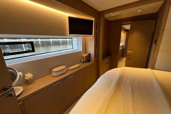 Sunlove Yacht Photos Pics Luxurious interior of 2024 Lagoon SIXTY 7 yacht bedroom with modern decor.