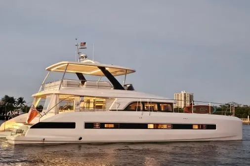 Sunlove Yacht Photos Pics 2024 Lagoon SIXTY 7 yacht on calm water at sunset, showcasing luxury design.