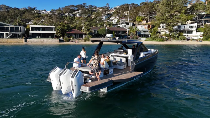  Yacht Photos Pics Schaefer V44 2024 yacht on water with passengers, coastal houses in background.