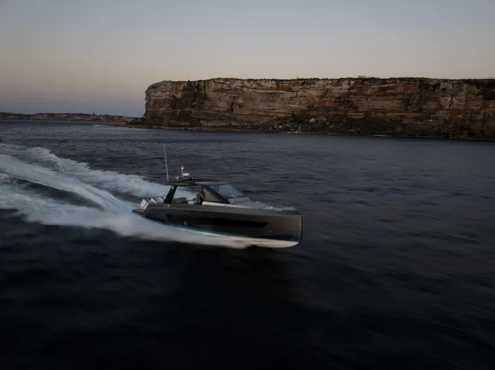  Yacht Photos Pics Schaefer V44 2024 yacht cruising at sunset along a rocky coastline.