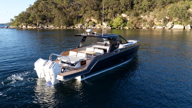  Yacht Photos Pics 2024 Schaefer V44 yacht on calm water near wooded shoreline.