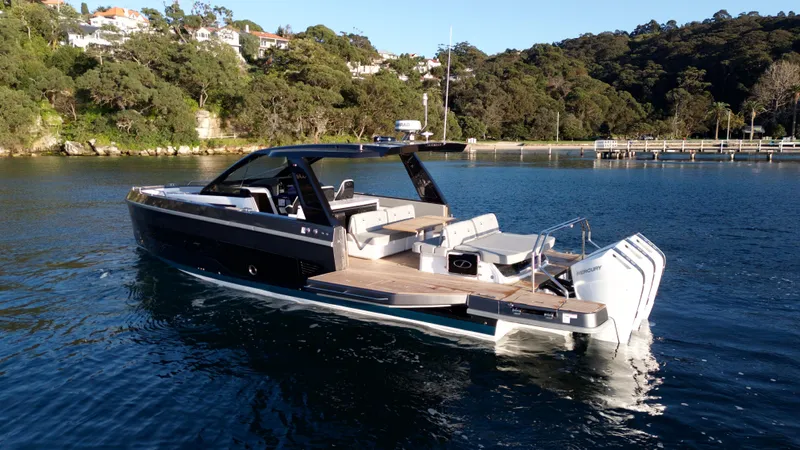  Yacht Photos Pics 2024 Schaefer V44 yacht on calm water near wooded shoreline.