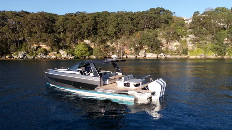  Yacht Photos Pics 2024 Schaefer V44 yacht on calm water near wooded shoreline.