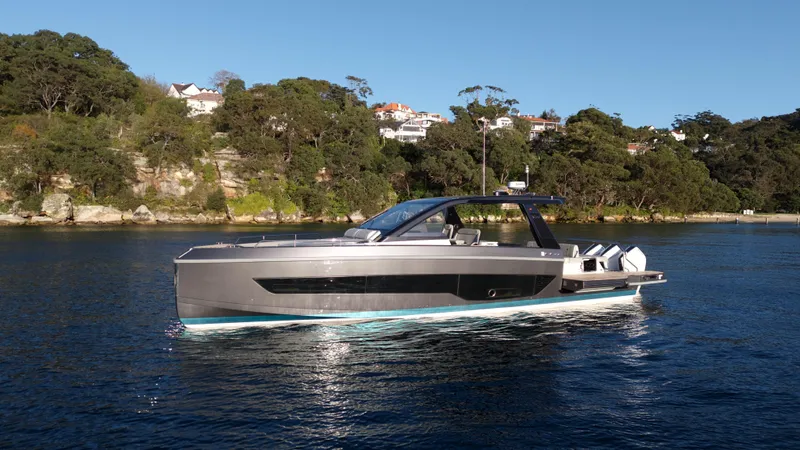  Yacht Photos Pics 2024 Schaefer V44 yacht on calm water near wooded shoreline.