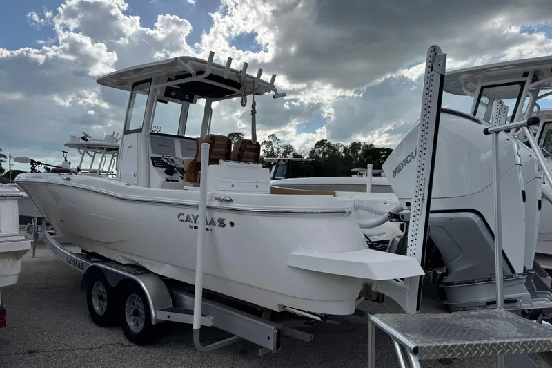  Yacht Photos Pics 2025 Caymas 291 boat on trailer, featuring Mercury engine, under cloudy sky.
