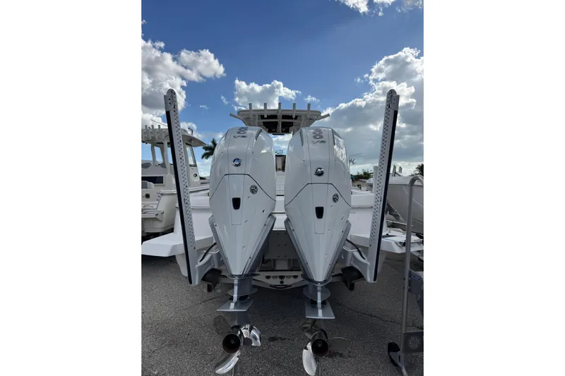  Yacht Photos Pics 2025 Caymas 291 boat with dual outboard engines under a partly cloudy sky.