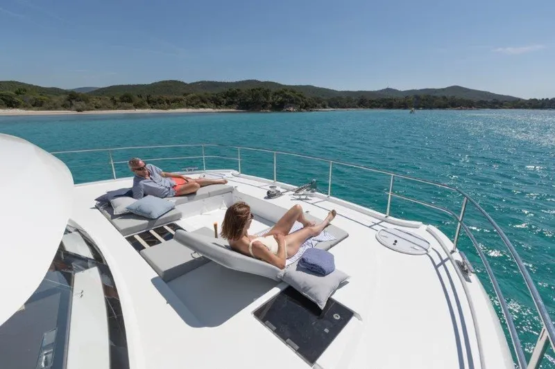  Yacht Photos Pics Couple relaxing on 2025 Fountaine Pajot MY6 yacht, enjoying sunny day at sea.