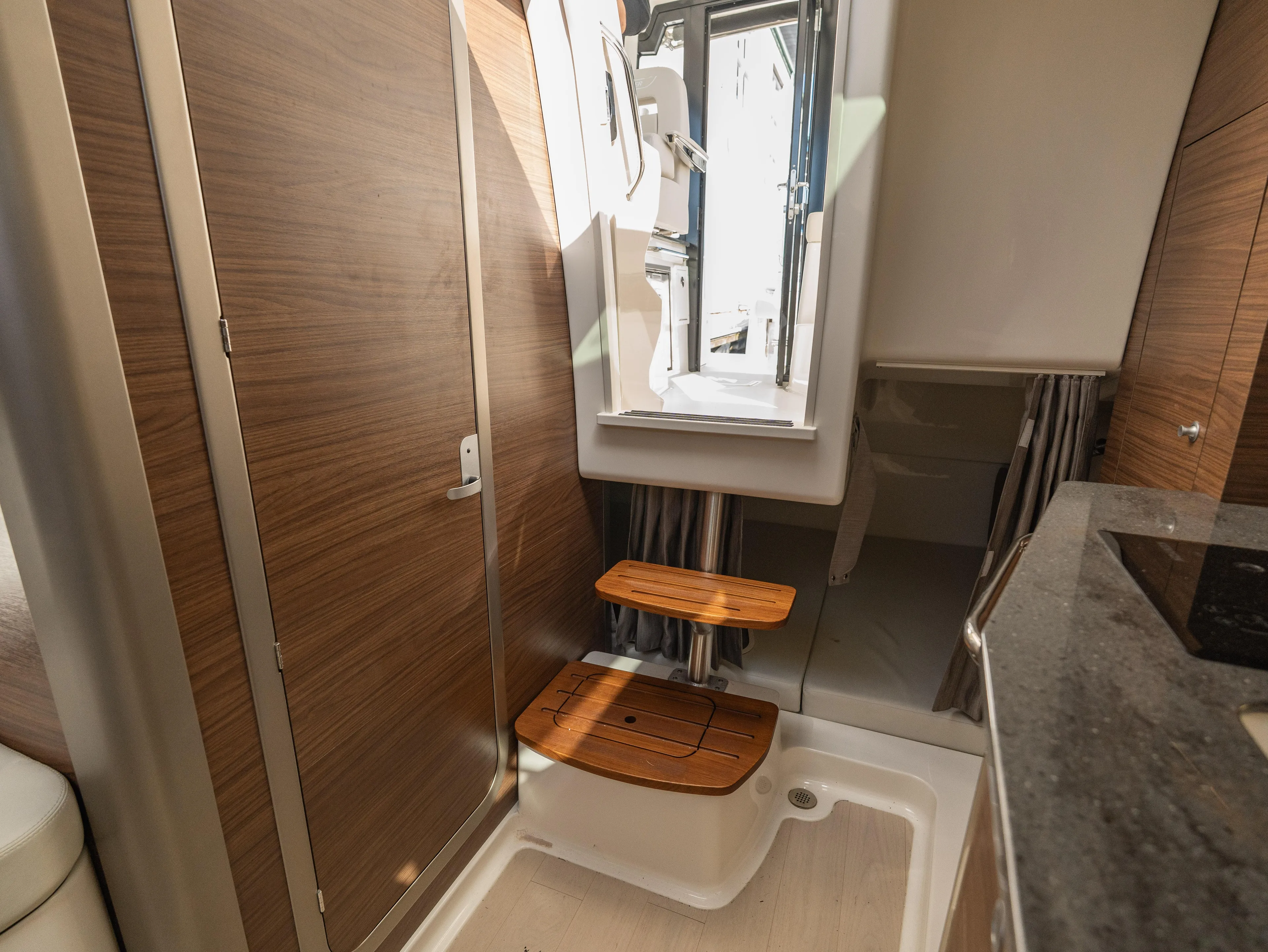  Yacht Photos Pics 2020 Boston Whaler 325 Conquest Pilothouse bathroom with wooden accents and window.