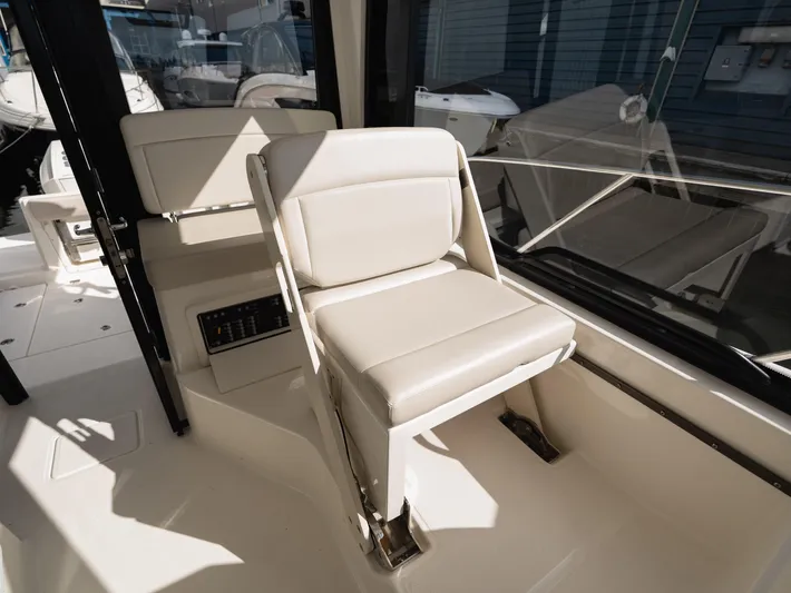  Yacht Photos Pics 2020 Boston Whaler 325 Conquest Pilothouse interior seating, featuring beige cushioned chair.