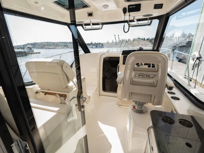  Yacht Photos Pics 2020 Boston Whaler 325 Conquest Pilothouse interior with helm and seating, overlooking water.