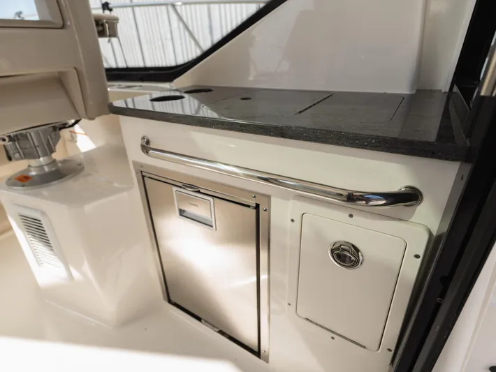  Yacht Photos Pics 2020 Boston Whaler 325 Conquest Pilothouse interior with sleek countertop and storage compartments.