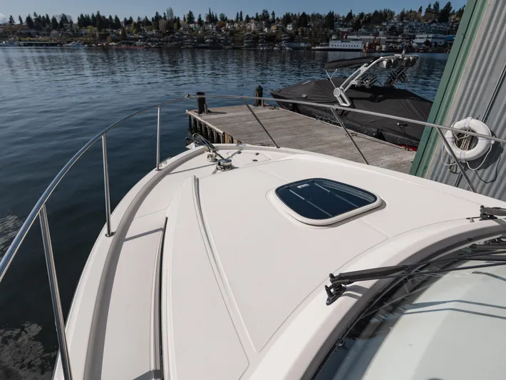  Yacht Photos Pics Boston Whaler 325 Conquest Pilothouse 2020 docked by a scenic waterfront.
