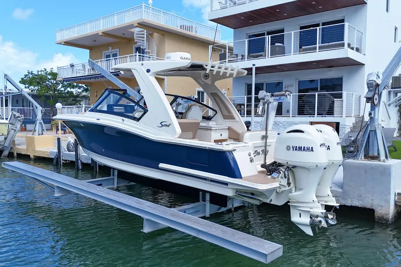  Yacht Photos Pics 2022 Scout 277 Dorado boat with Yamaha engines docked near modern waterfront home.
