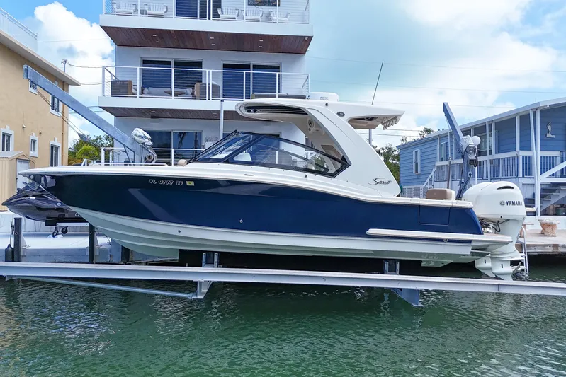  Yacht Photos Pics 2022 Scout 277 Dorado boat docked near waterfront homes.