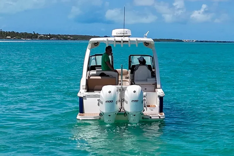  Yacht Photos Pics 2022 Scout 277 Dorado boat on turquoise water with two people onboard.