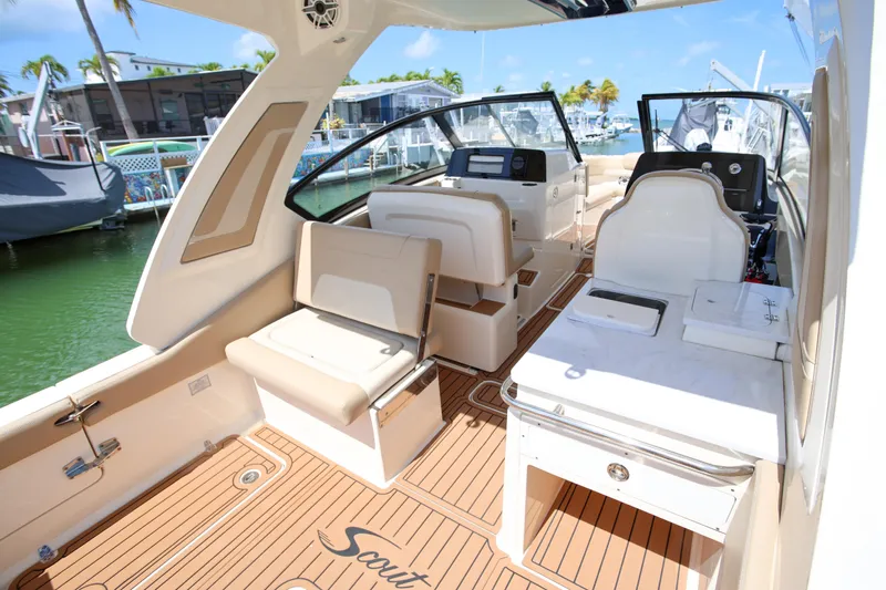  Yacht Photos Pics 2022 Scout 277 Dorado boat interior with seating and helm, docked in a marina.