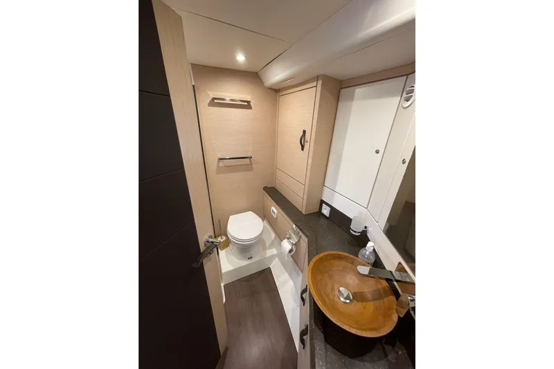  Yacht Photos Pics Luxurious bathroom in 2017 Jeanneau 64 yacht with modern fixtures and wooden accents.