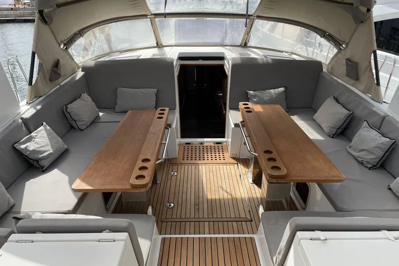  Yacht Photos Pics Luxurious 2017 Jeanneau 64 yacht cockpit with wooden tables and cushioned seating.
