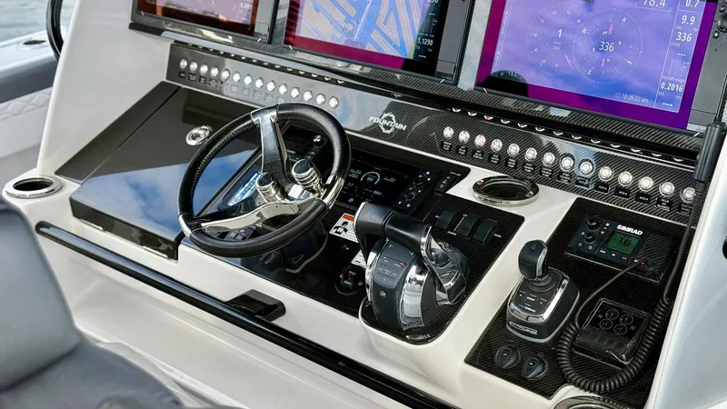  Yacht Photos Pics Control panel of 2020 Fountain 43NX boat with advanced navigation displays and steering wheel.