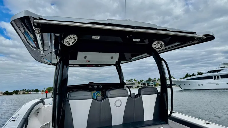  Yacht Photos Pics 2020 Fountain 43NX boat with sleek seating and canopy on a calm waterway.