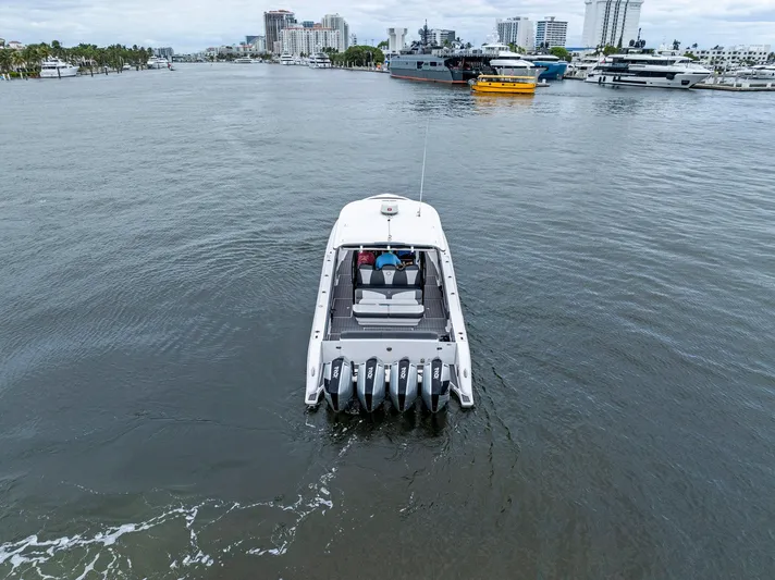  Yacht Photos Pics 2020 Fountain 43NX boat cruising in a marina with cityscape background.