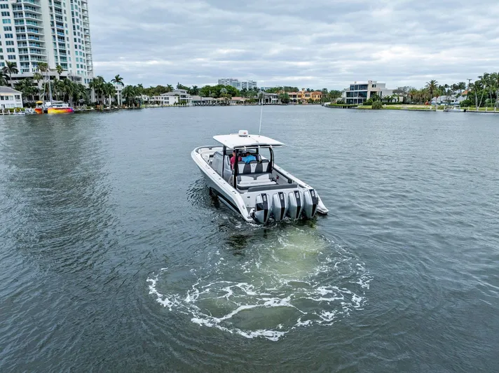  Yacht Photos Pics Fountain 43NX boat cruising on a calm waterway, surrounded by modern buildings, 2020 model.