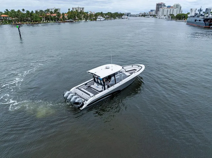  Yacht Photos Pics Fountain 43NX 2020 boat cruising on a calm waterway with cityscape background.