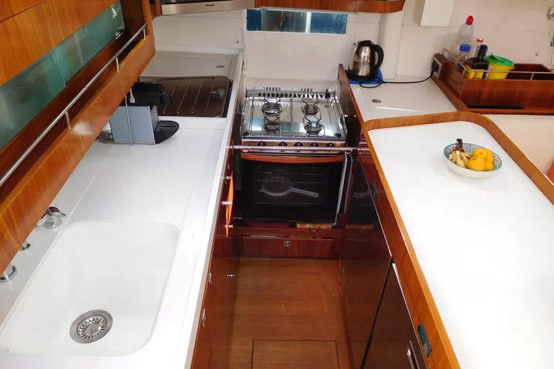  Yacht Photos Pics Luxurious kitchen interior of 2011 Amel 55 yacht with modern appliances and wooden cabinetry.