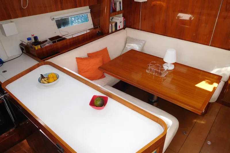  Yacht Photos Pics Luxurious interior of 2011 Amel 55 yacht with wooden dining area and cozy seating.