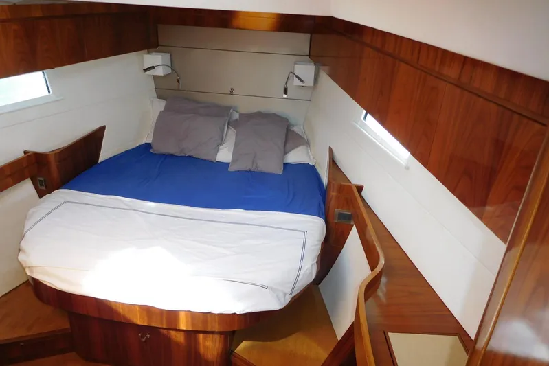  Yacht Photos Pics Luxurious cabin interior of 2011 Amel 55 yacht with wooden finish and cozy bedding.