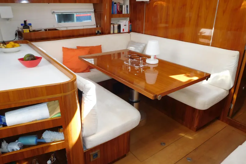  Yacht Photos Pics Luxurious interior of 2011 Amel 55 yacht with wooden dining area and cozy seating.