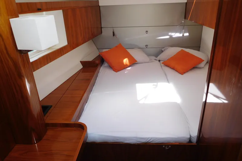  Yacht Photos Pics Luxurious cabin interior of 2011 Amel 55 yacht with cozy bed and orange pillows.