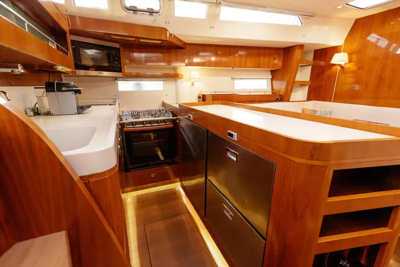  Yacht Photos Pics Luxurious kitchen interior of 2011 Amel 55 yacht with modern appliances and wood finish.