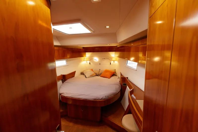  Yacht Photos Pics Luxurious cabin interior of 2011 Amel 55 yacht with wooden finish and cozy bed.