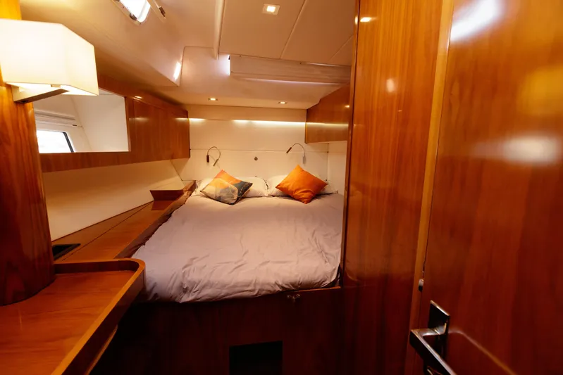 Yacht Photos Pics Luxurious cabin interior of 2011 Amel 55 yacht with cozy bed and wooden finish.