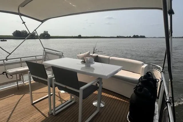 Luxury deck of 2017 Elling E4 yacht with seating and table, overlooking serene waters.